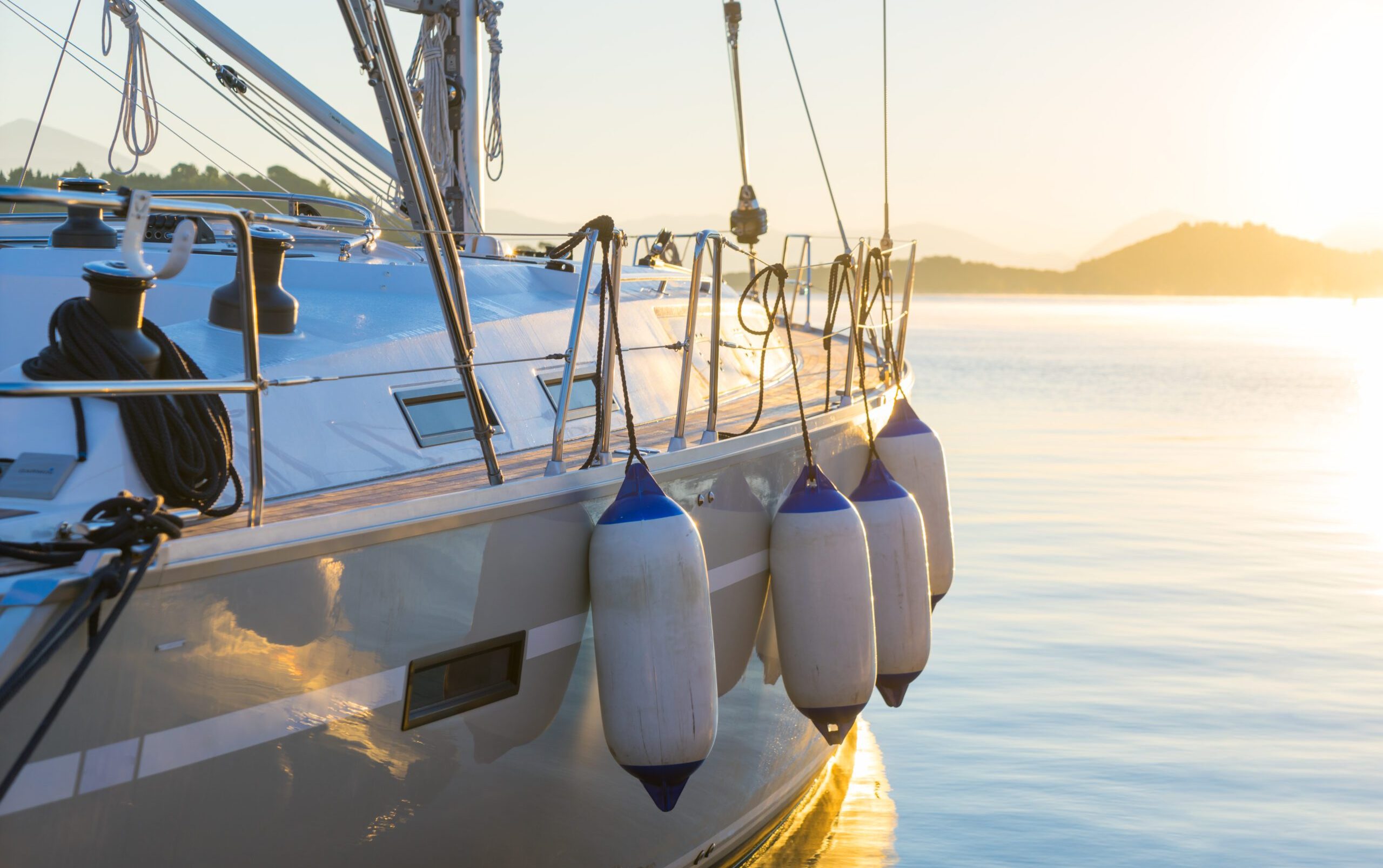 Sailing yacht boat on on ocean water at sunrise